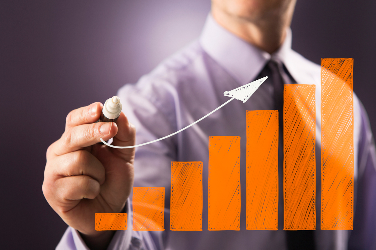 man drawing bar chart on marker board